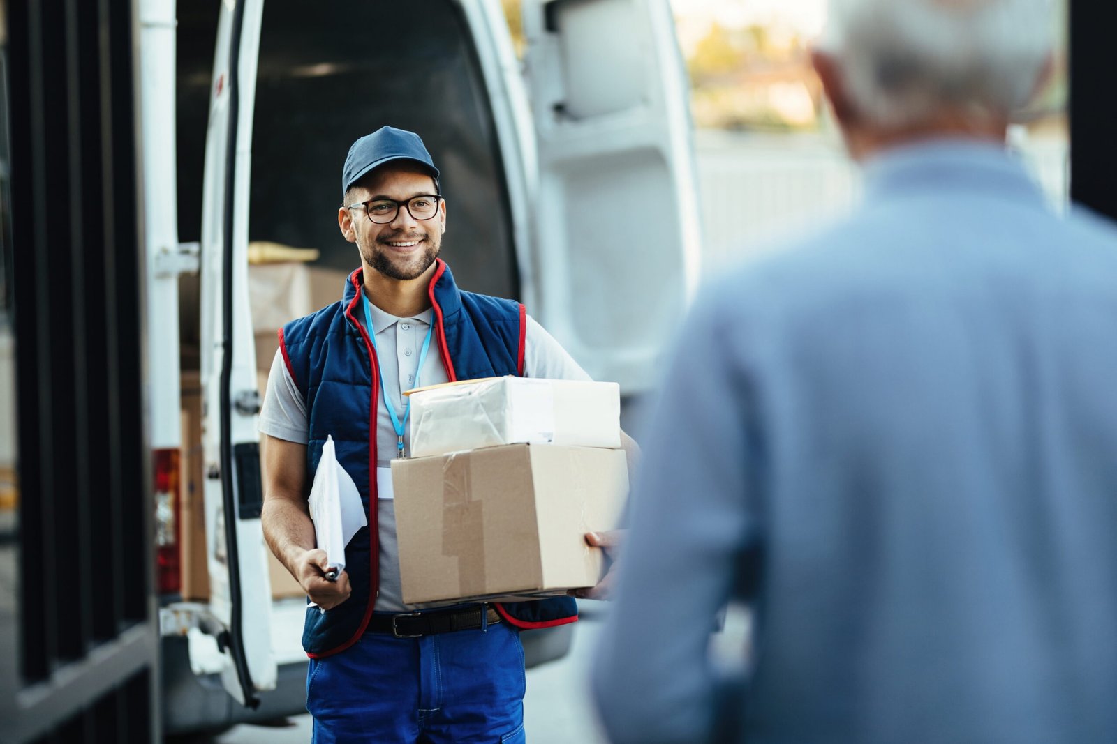 happy-deliverer-carrying-packages-while-making-home-delivery-his-customer (1)